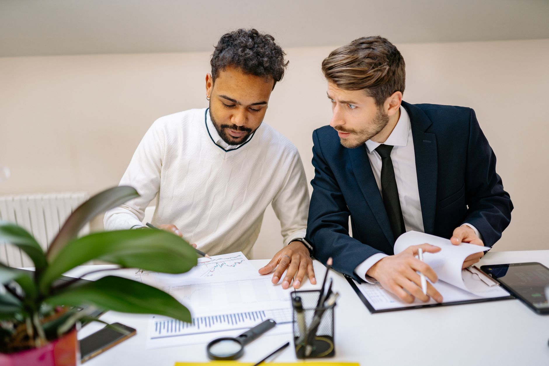 Two colleagues reviewing a document together at an office desk